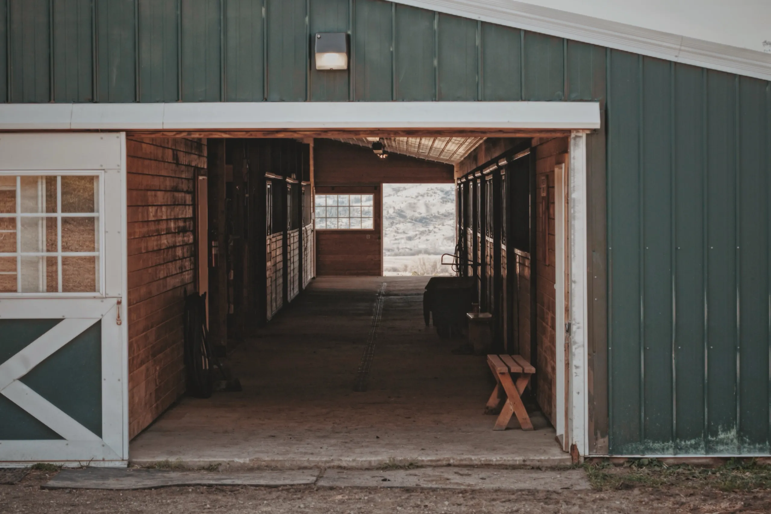 Through the barn doorway, down the stall aisle
