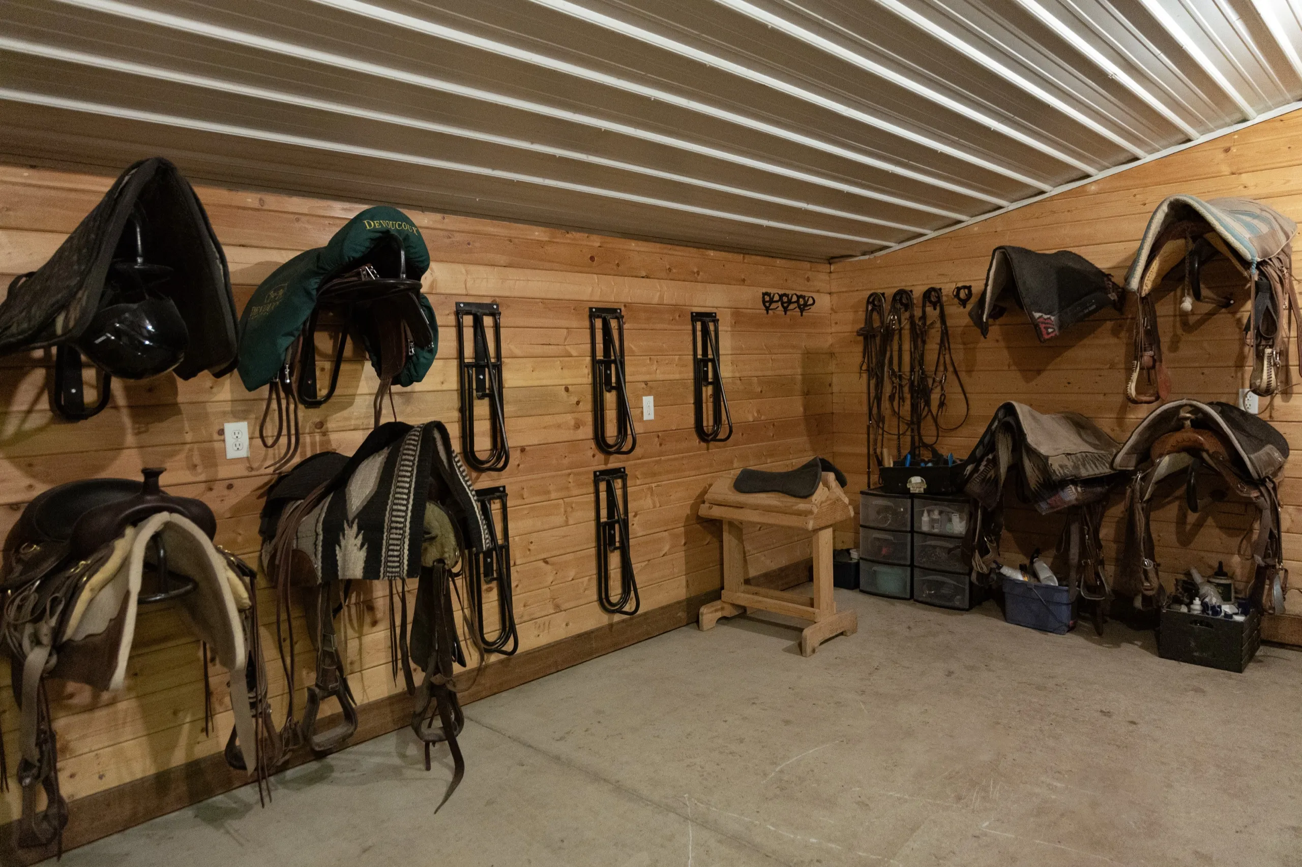 The tack room, saddles and bridles on the wall