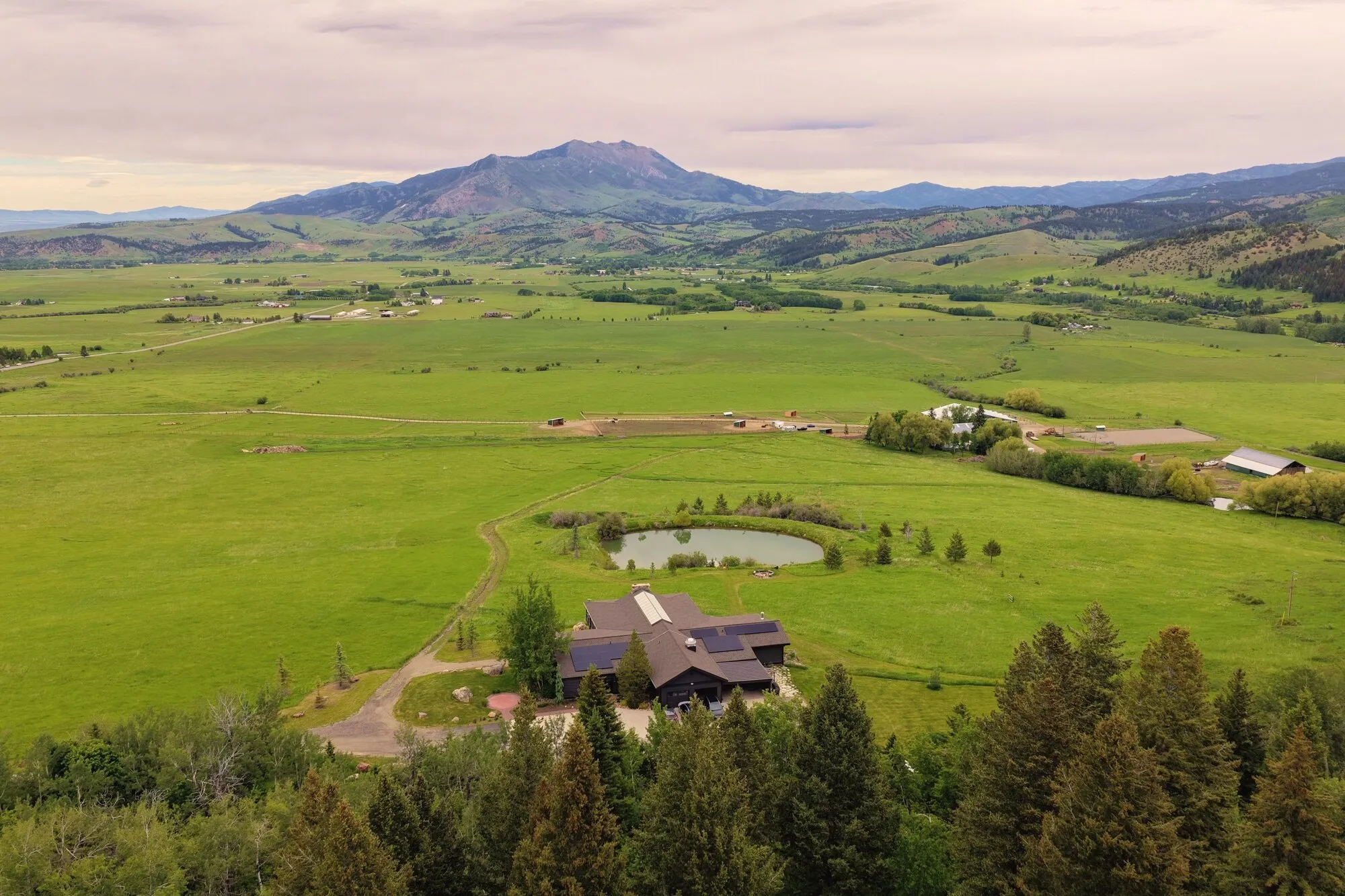 Aerial view of Four Peaks Ranch: lodge, ponds, and meadows below Mount Ellis