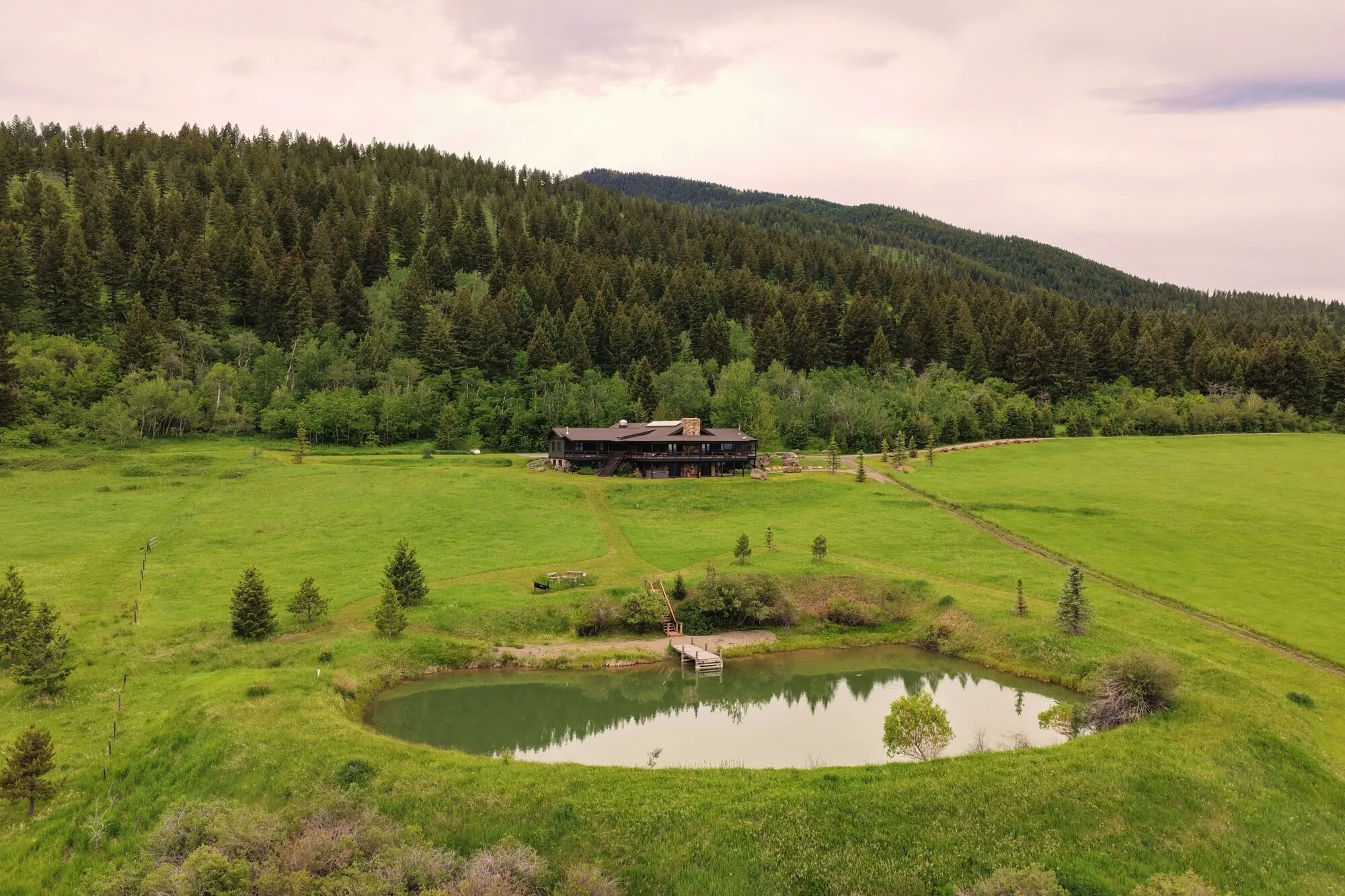 A pond in the meadows with a distant view of the lodge
