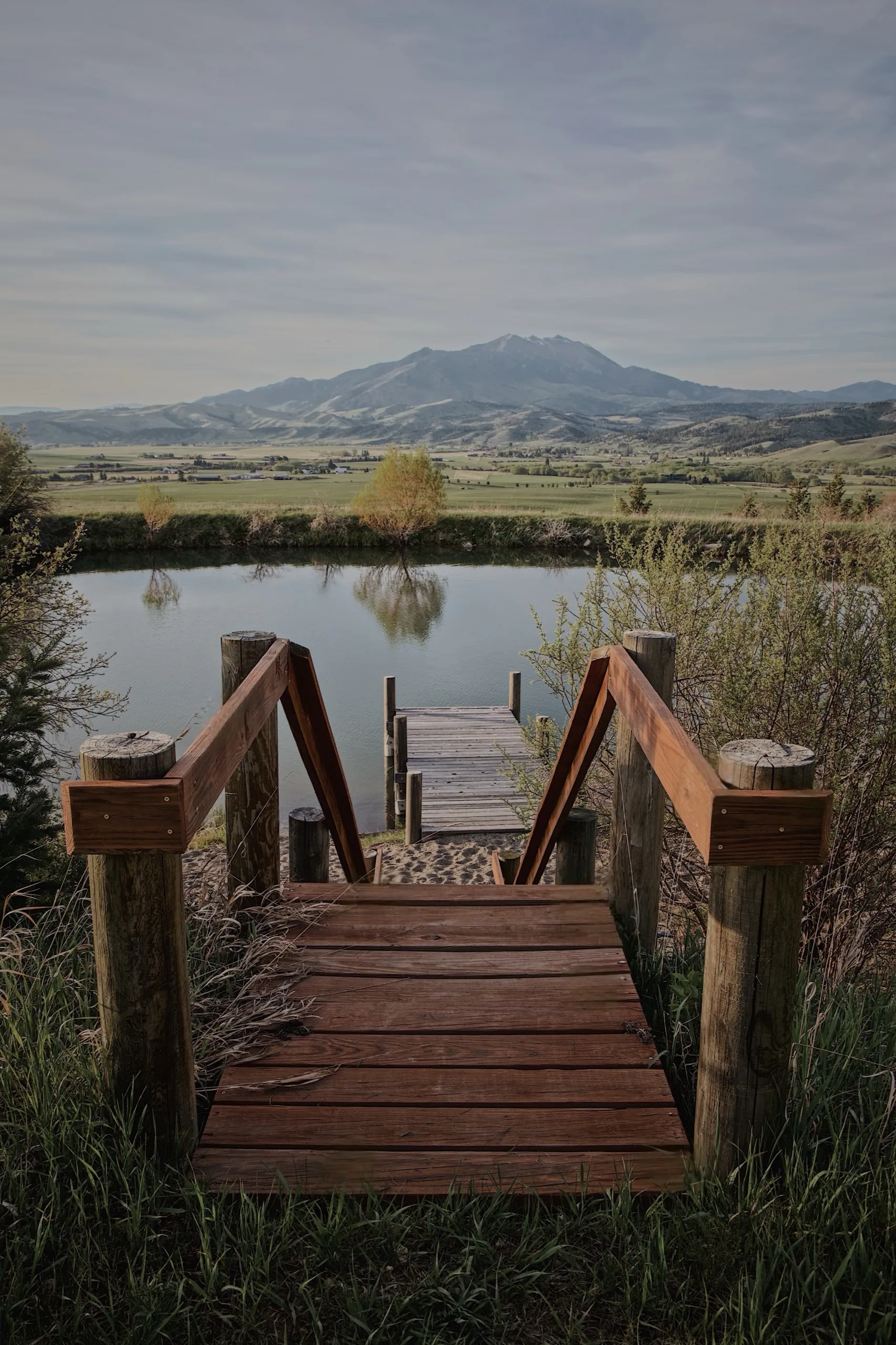 A wooden walkway down to the pond dock, the mountain beyond