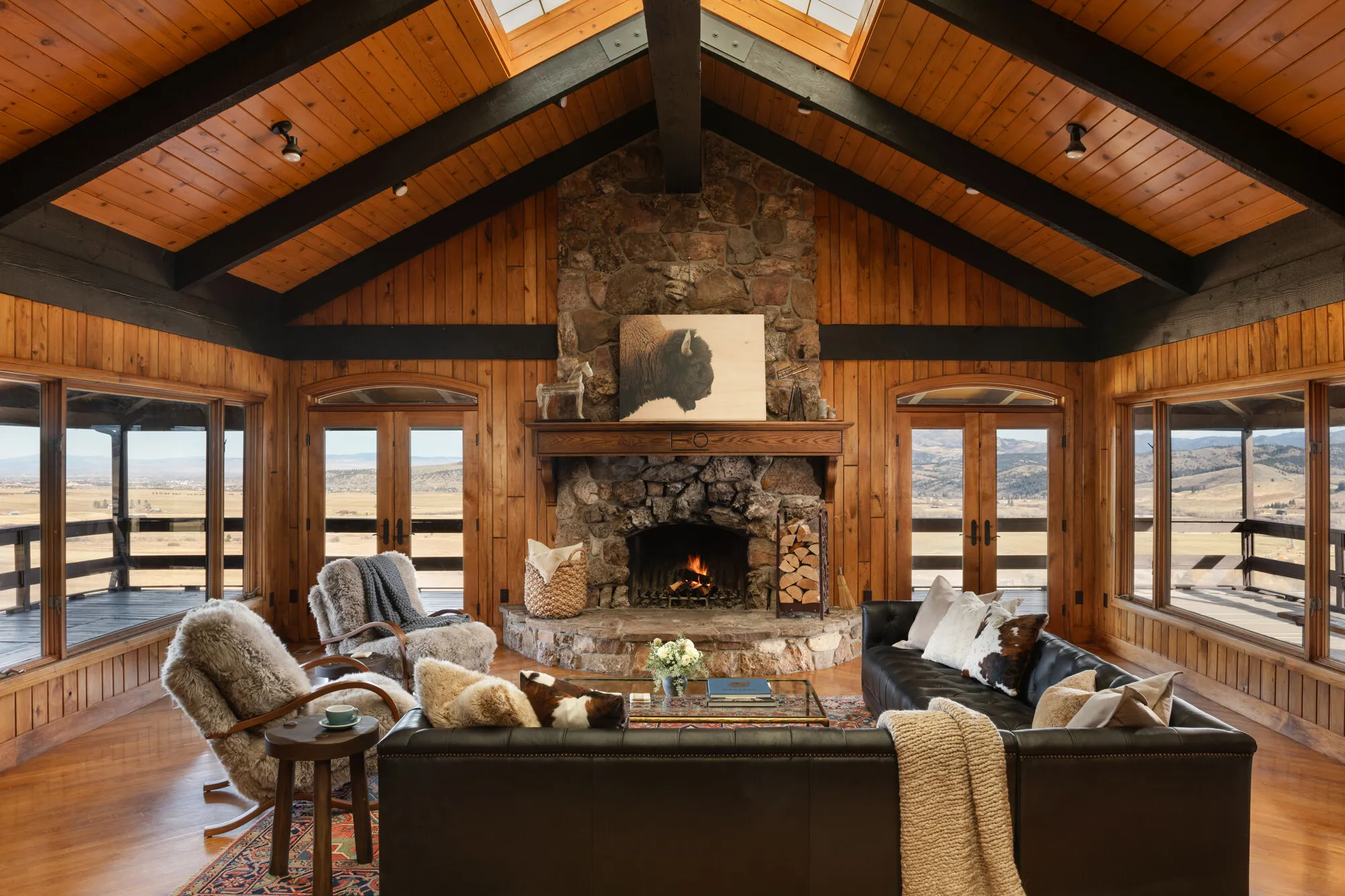 The lodge great room: stone fireplace under a vaulted timber ceiling