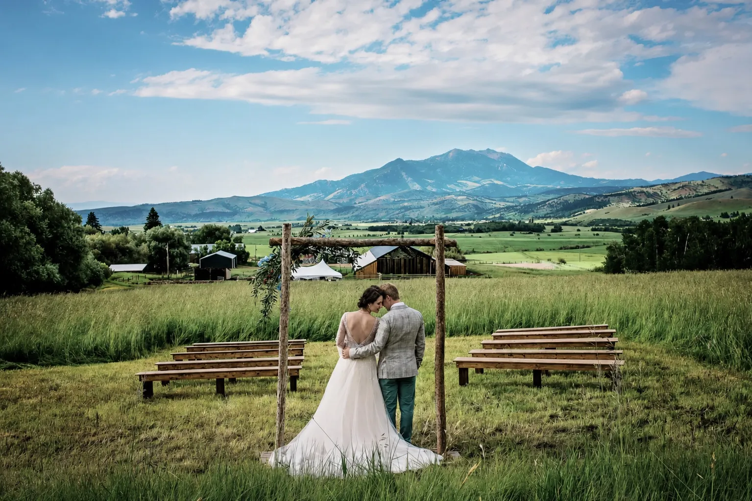 A wedding couple enjoying the open meadows and mountain views from one of our wedding sites